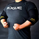 Athlete flexing while wearing Power Dragon elbow sleeves, showcasing support and sleek design